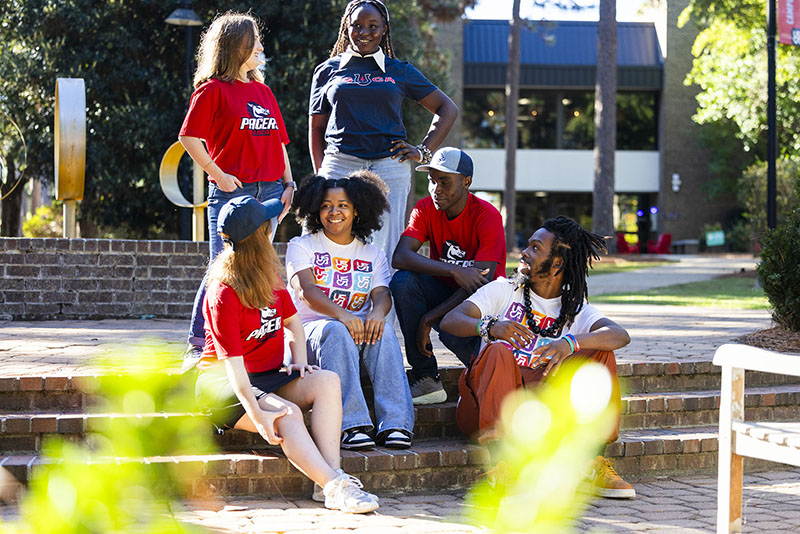 Six students seated at the USCA fountain