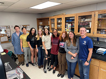 Group of nine people in a science lab