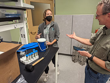 Two people working in a science lab near test tubes filled with Sabal Palm samples.